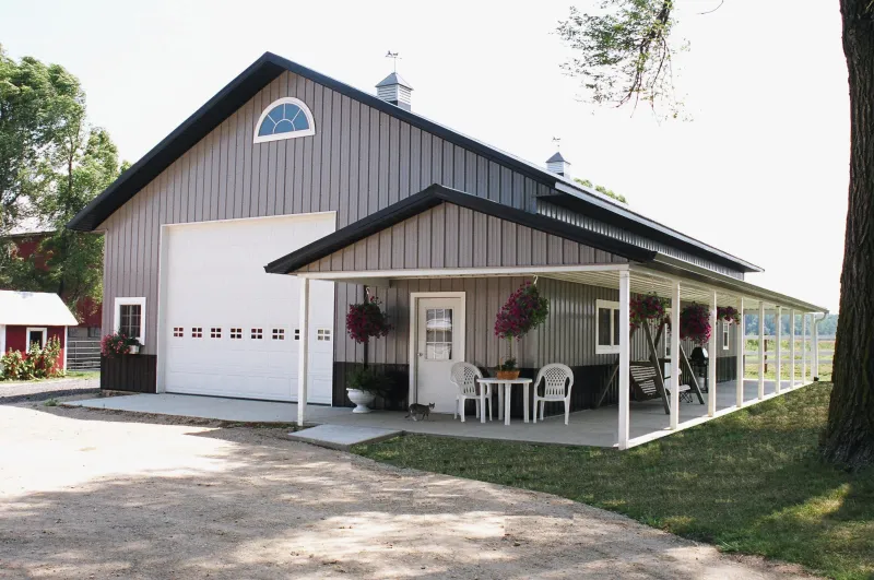 Completed post-frame pole barn with an open garage bay and covered porch